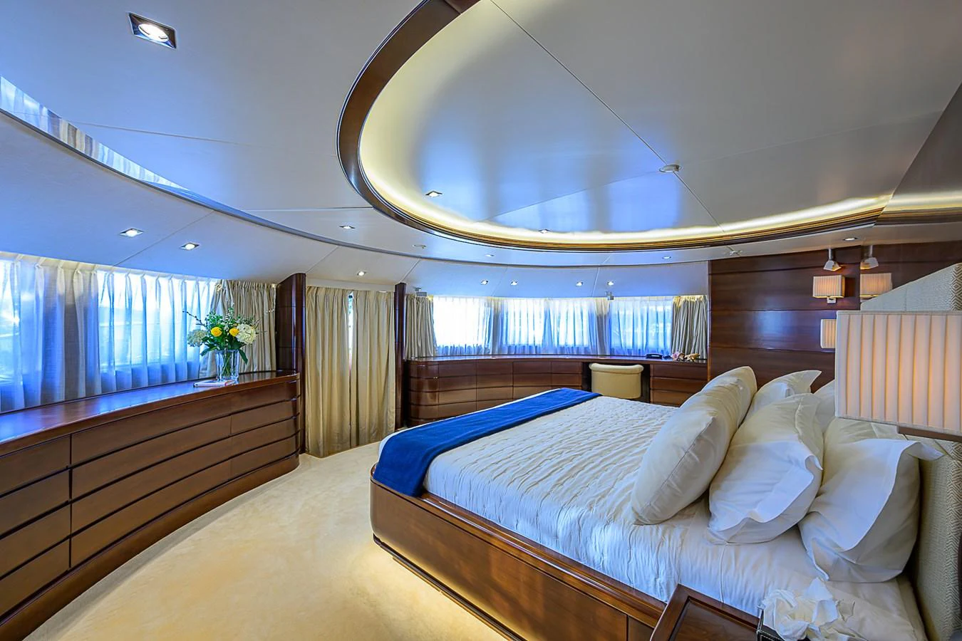 The master stateroom features luxurious bedding and elegant wood finishes, creating a serene and opulent retreat. aboard SEASCAPE V Yacht for Sale