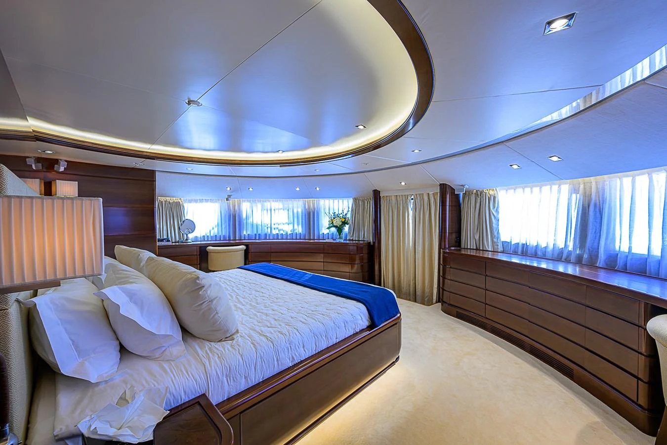 The master stateroom features a spacious bed, elegant wood finishes, and ample natural light. aboard SEASCAPE V Yacht for Sale