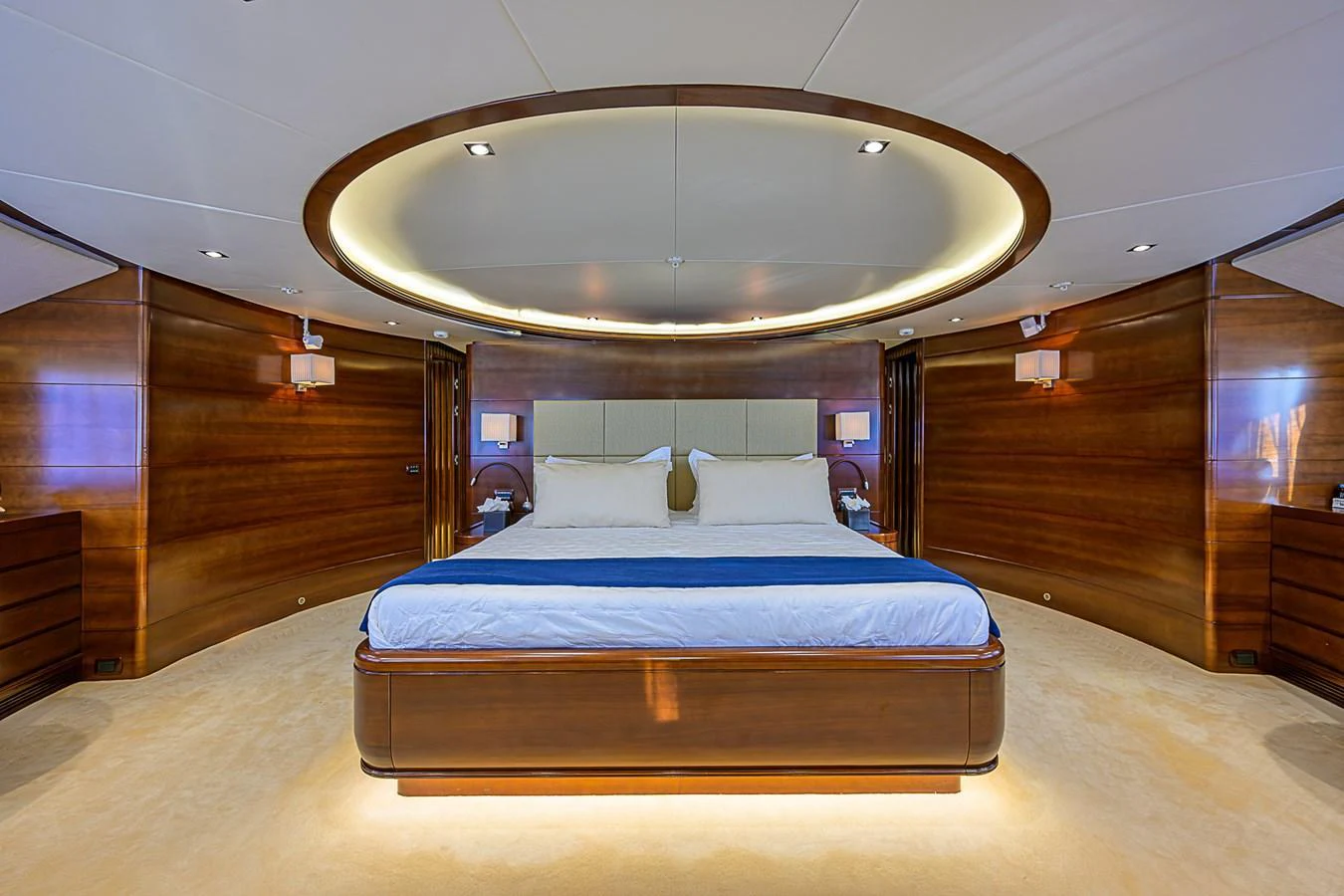 The master stateroom features a luxurious bed with elegant wood paneling and ambient lighting. aboard SEASCAPE V Yacht for Sale