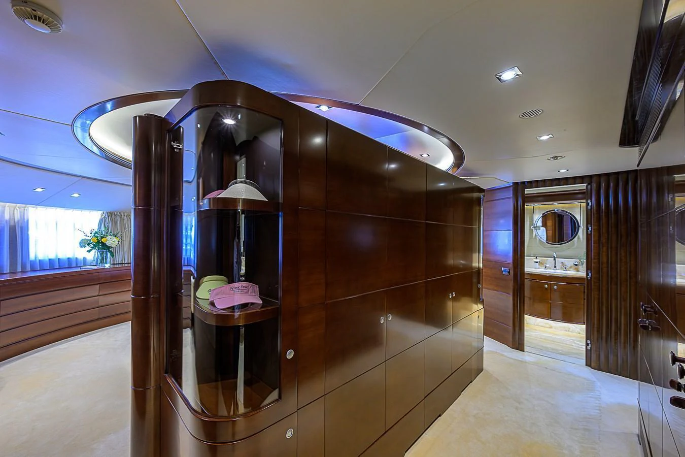 The yacht's interior features elegant wood paneling and a well-lit hallway leading to a luxurious bathroom. aboard SEASCAPE V Yacht for Sale