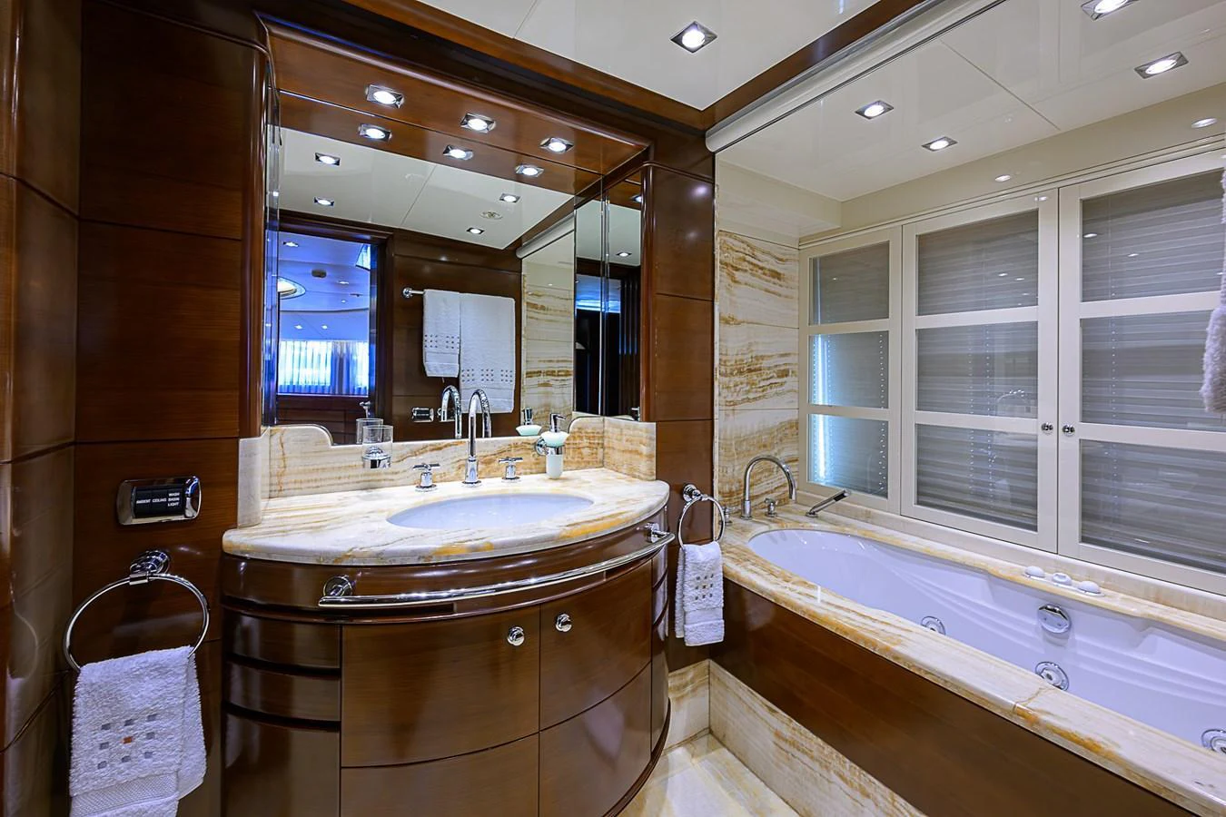 The yacht's bathroom features luxurious wood paneling and a marble countertop with a spacious bathtub. aboard SEASCAPE V Yacht for Sale