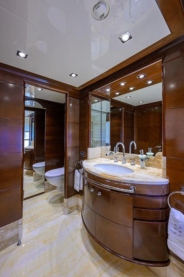 This image showcases a luxurious yacht bathroom with elegant wood finishes and modern fixtures. aboard SEASCAPE V Yacht for Sale