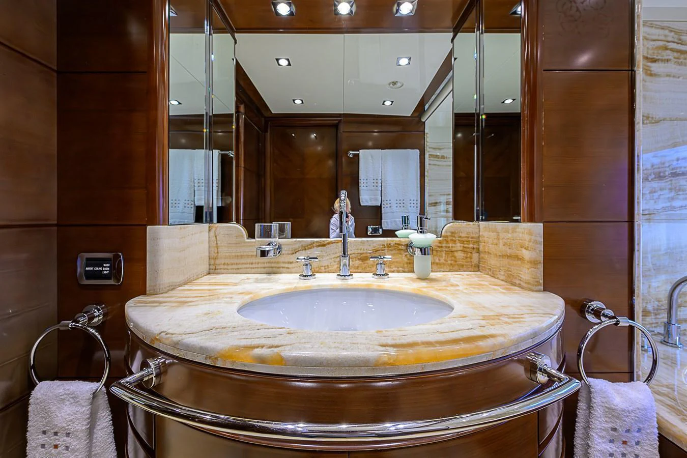 The yacht's bathroom features luxurious wood paneling and a marble countertop with elegant fixtures. aboard SEASCAPE V Yacht for Sale