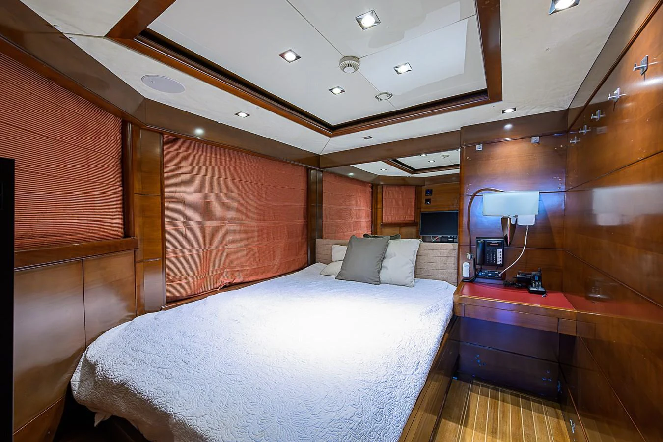A luxurious stateroom featuring a large bed with elegant wood paneling and ambient lighting. aboard SEASCAPE V Yacht for Sale