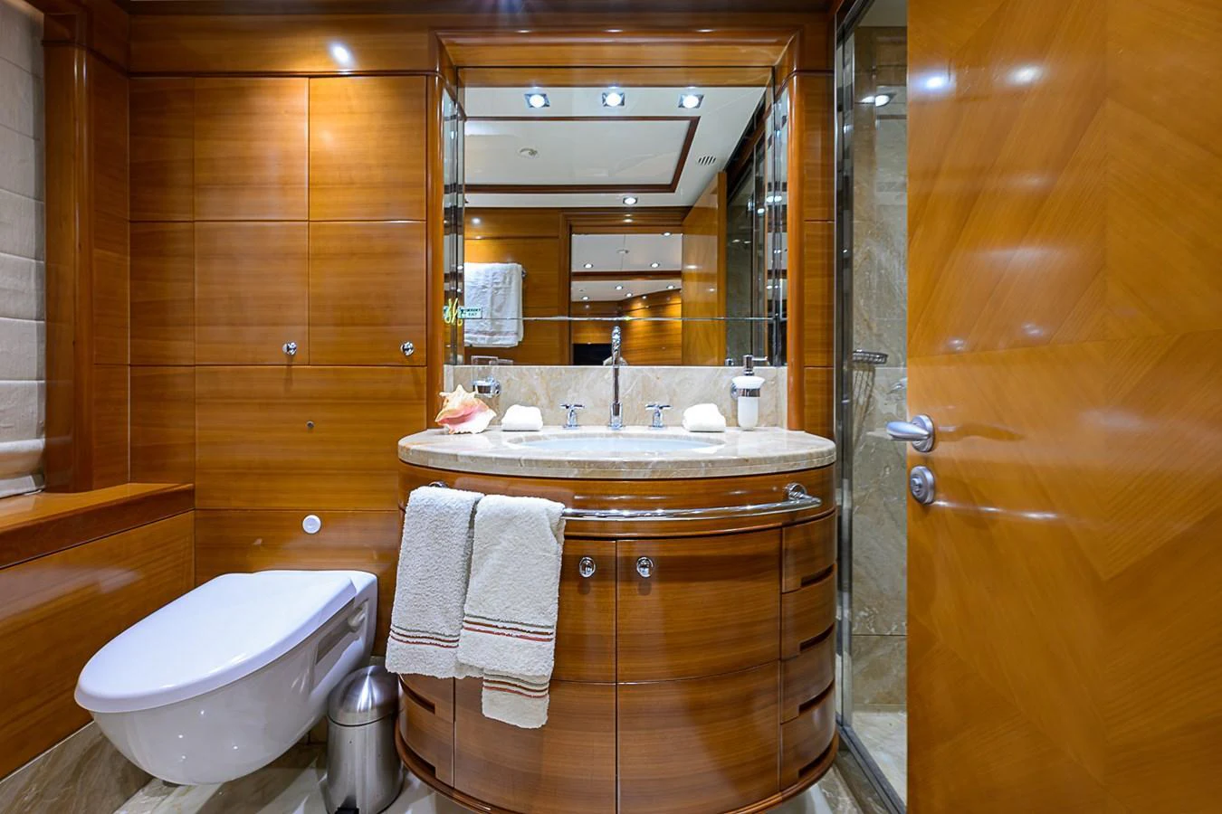 The yacht's bathroom features elegant wood paneling and modern fixtures. aboard SEASCAPE V Yacht for Sale