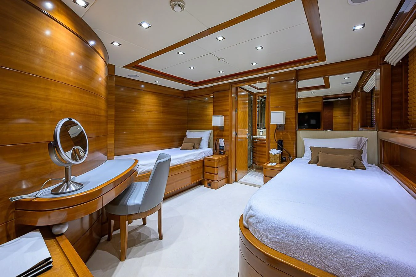 The twin stateroom features elegant wood paneling and modern amenities for a comfortable stay. aboard SEASCAPE V Yacht for Sale