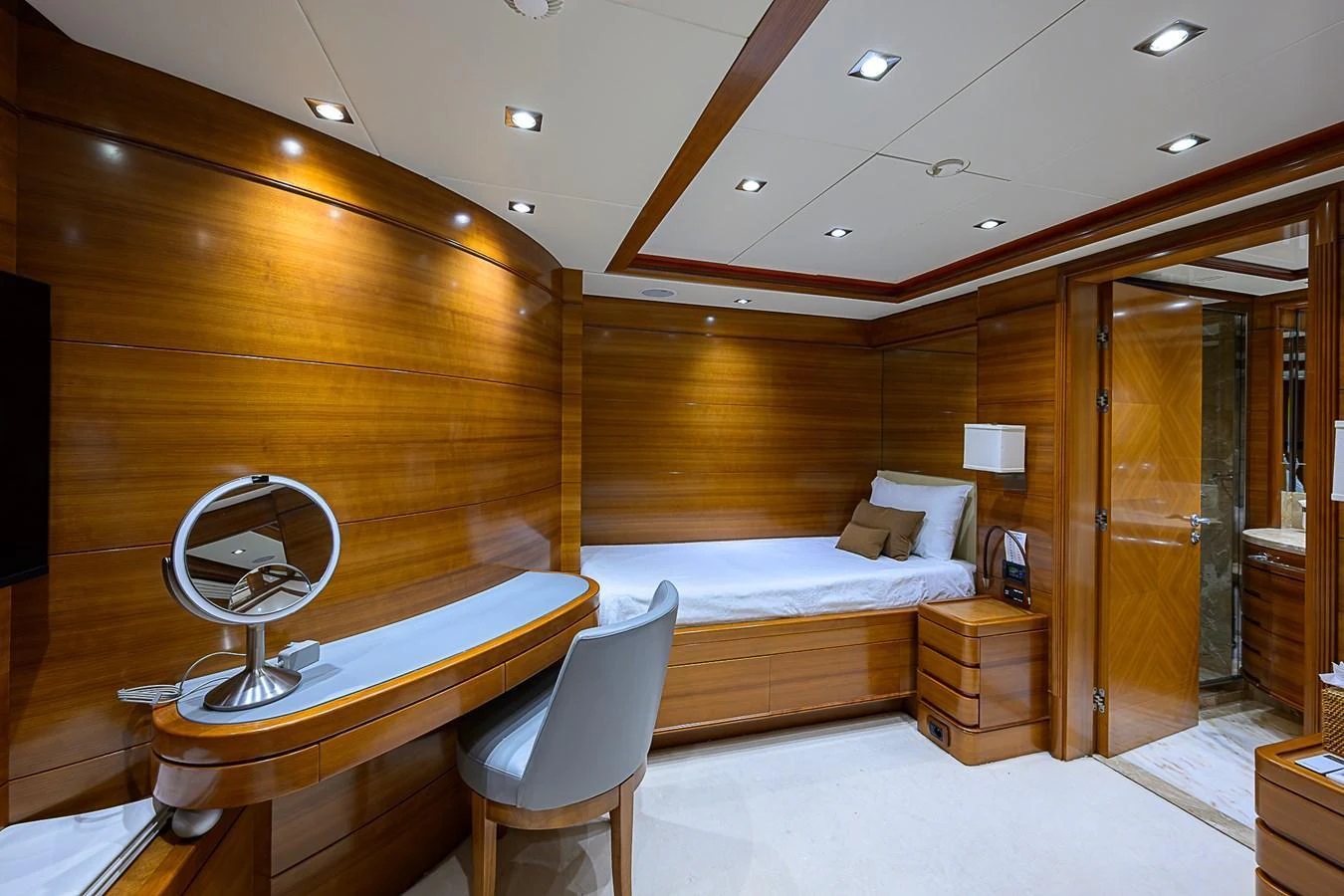 A luxurious stateroom featuring rich wood paneling and modern amenities. aboard SEASCAPE V Yacht for Sale