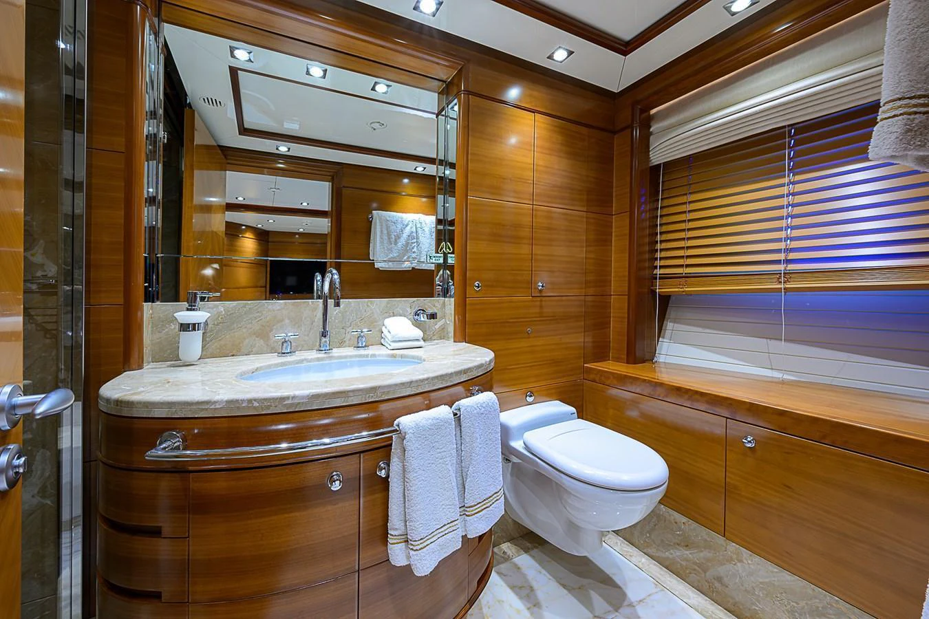 The yacht's bathroom features luxurious wood paneling and modern fixtures. aboard SEASCAPE V Yacht for Sale