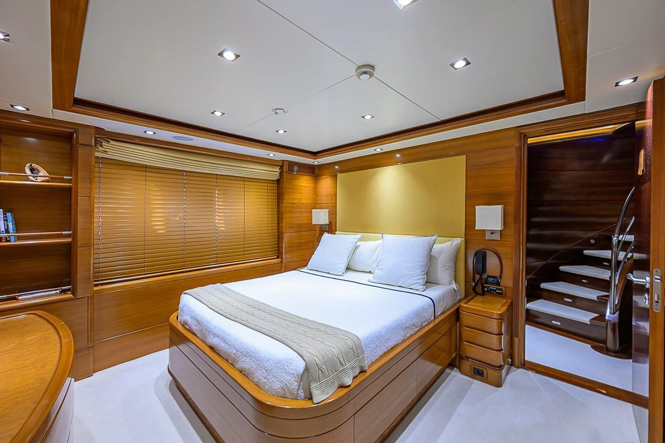The master stateroom features a spacious bed with elegant wooden accents and modern lighting. aboard SEASCAPE V Yacht for Sale