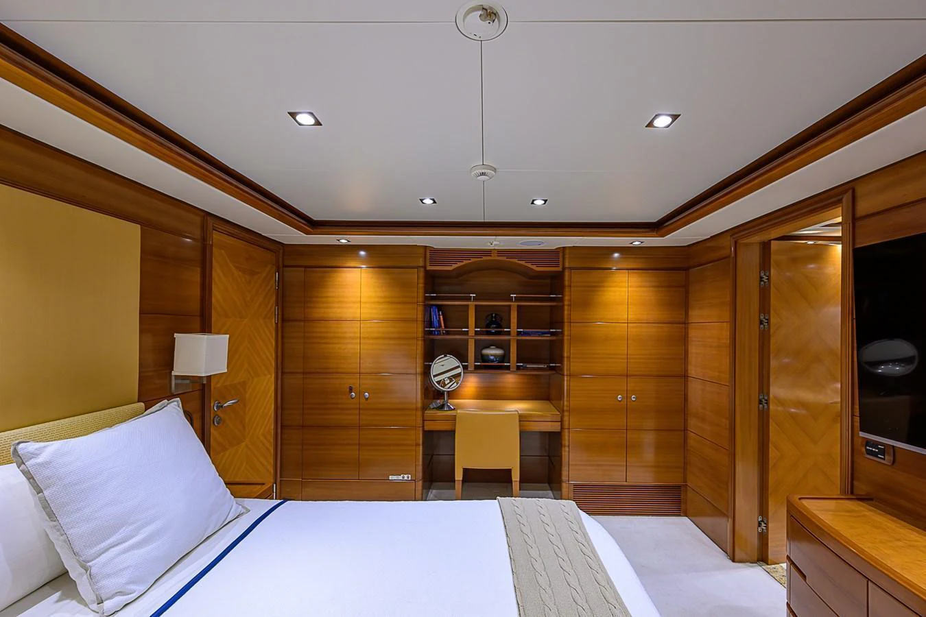 The stateroom features elegant wood paneling and a cozy workspace. aboard SEASCAPE V Yacht for Sale