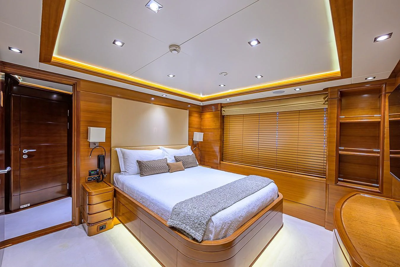 The master stateroom features a luxurious bed with elegant wood paneling and ambient lighting. aboard SEASCAPE V Yacht for Sale