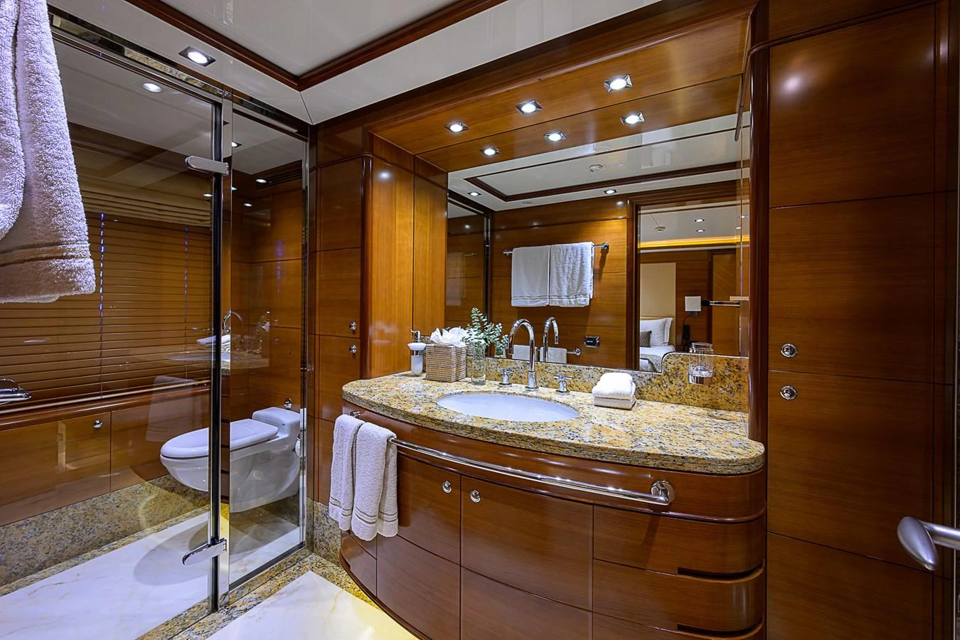 The yacht's bathroom features luxurious wood paneling and a spacious vanity with granite countertops. aboard SEASCAPE V Yacht for Sale