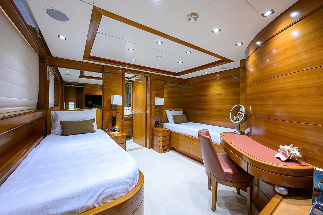 The twin stateroom features elegant wood paneling and comfortable twin beds, creating a warm and inviting atmosphere. aboard SEASCAPE V Yacht for Sale