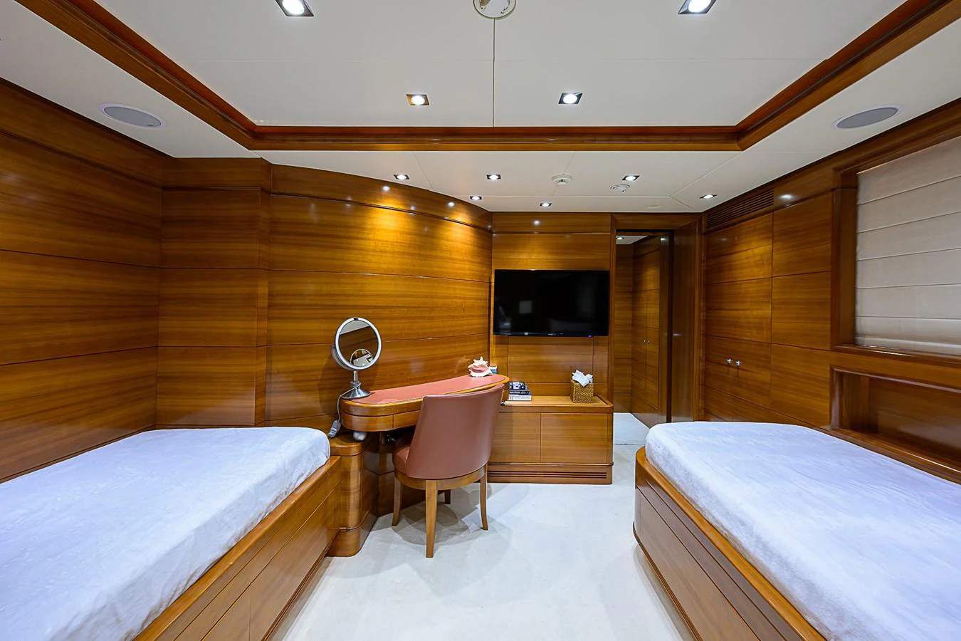 A luxurious twin stateroom with rich wood paneling and modern amenities. aboard SEASCAPE V Yacht for Sale