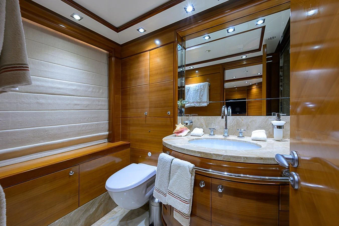 The yacht's bathroom features luxurious wood paneling and modern fixtures. aboard SEASCAPE V Yacht for Sale