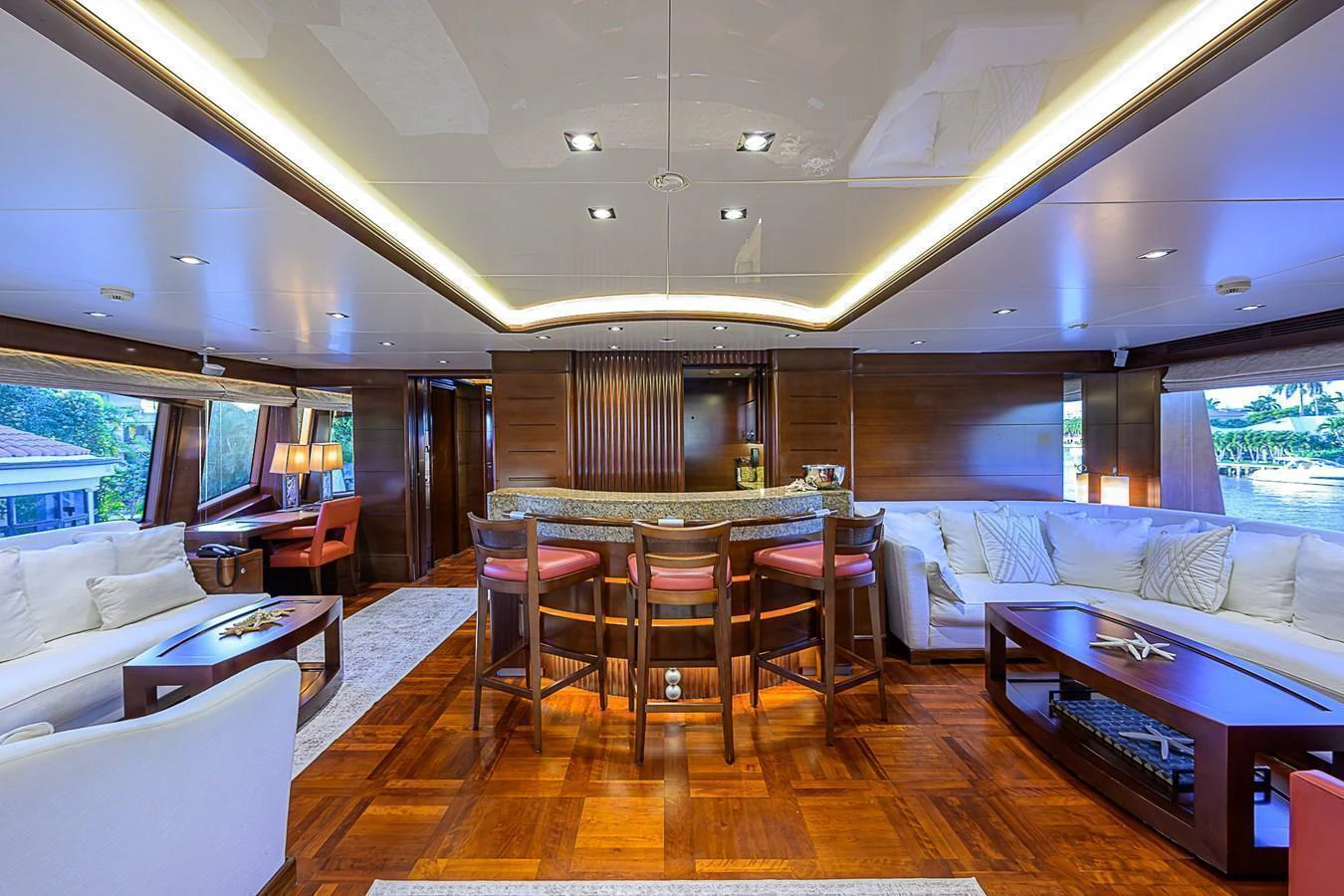 The yacht's salon features a spacious seating area with a bar and elegant wood finishes. aboard SEASCAPE V Yacht for Sale