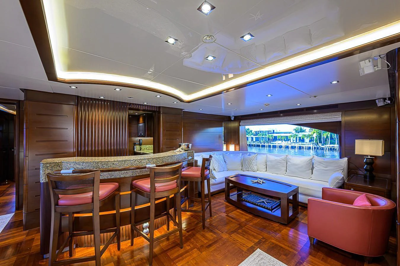 The salon features a luxurious seating area with a bar and modern lighting. aboard SEASCAPE V Yacht for Sale
