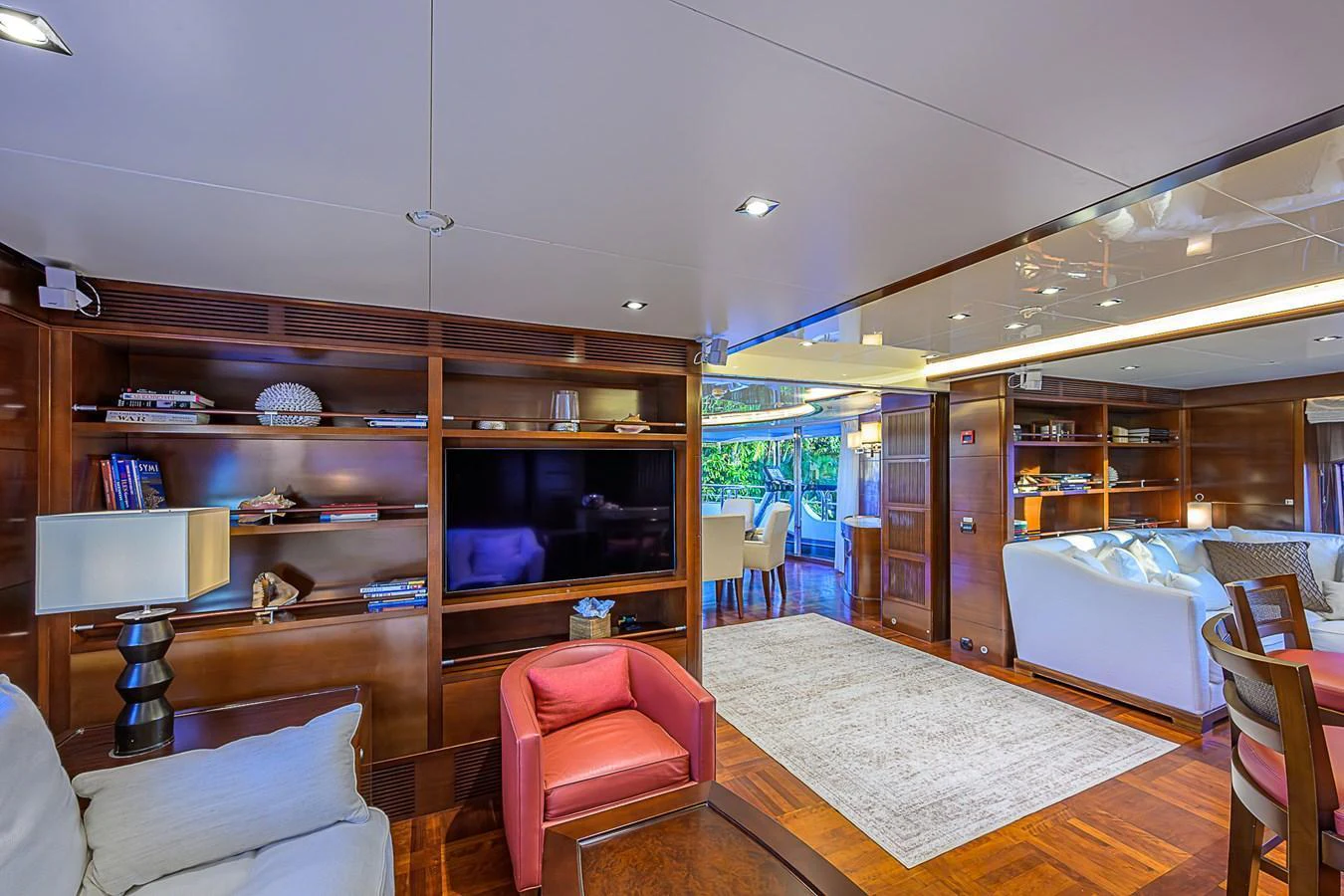 The yacht's salon features luxurious seating, a large television, and elegant wooden cabinetry. aboard SEASCAPE V Yacht for Sale