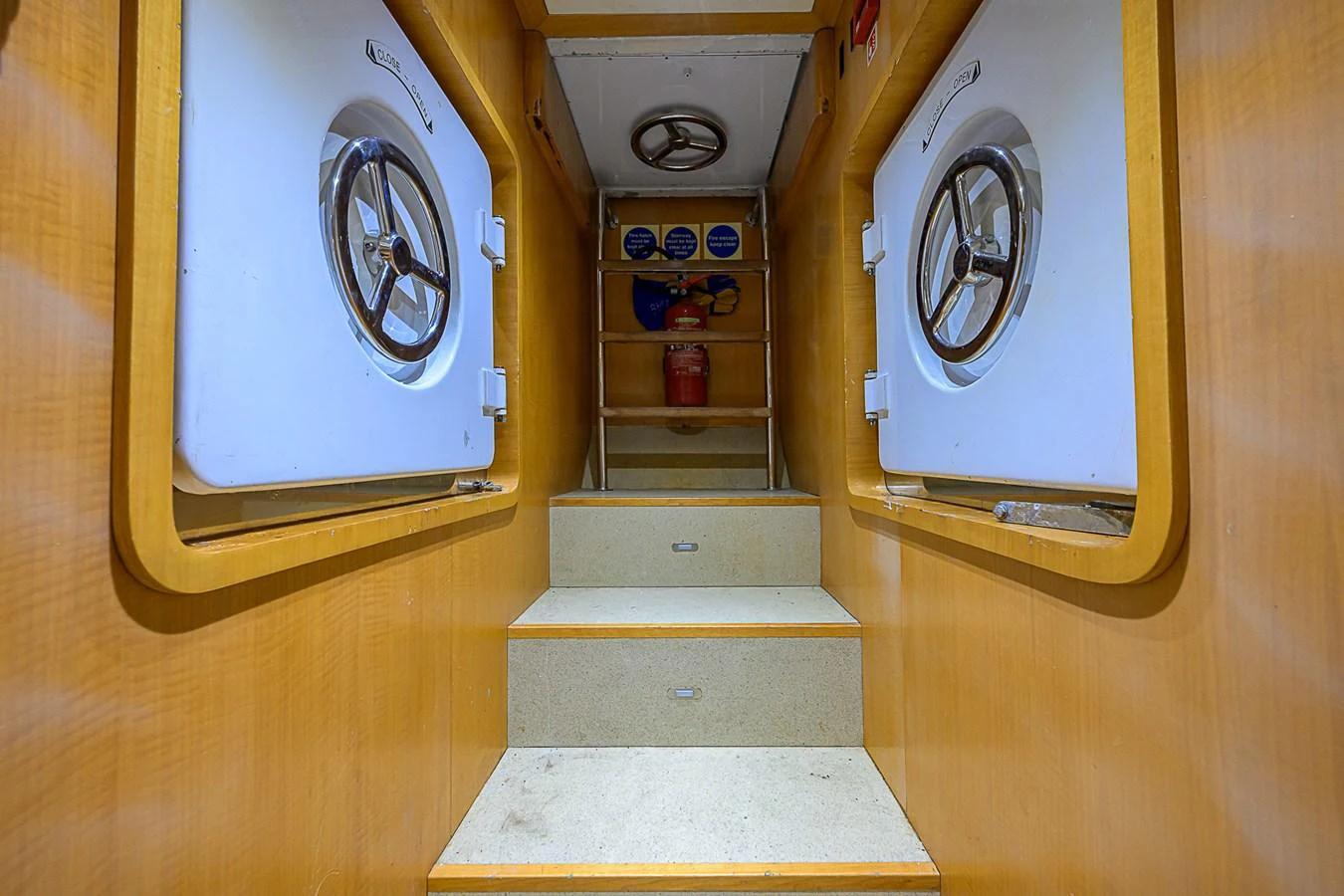 A well-maintained interior passageway with secure hatch doors and steps leading upwards. aboard SEASCAPE V Yacht for Sale