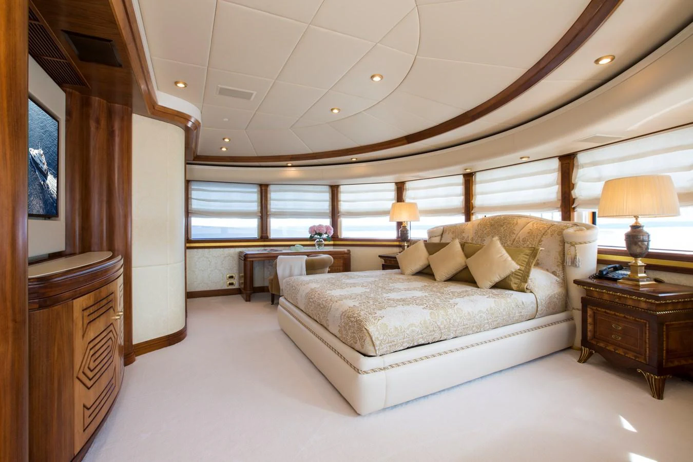 The master stateroom features a luxurious bed with elegant bedding, surrounded by warm wooden accents and ample natural light. aboard ALASKA OF GEORGE TOWN Yacht for Sale