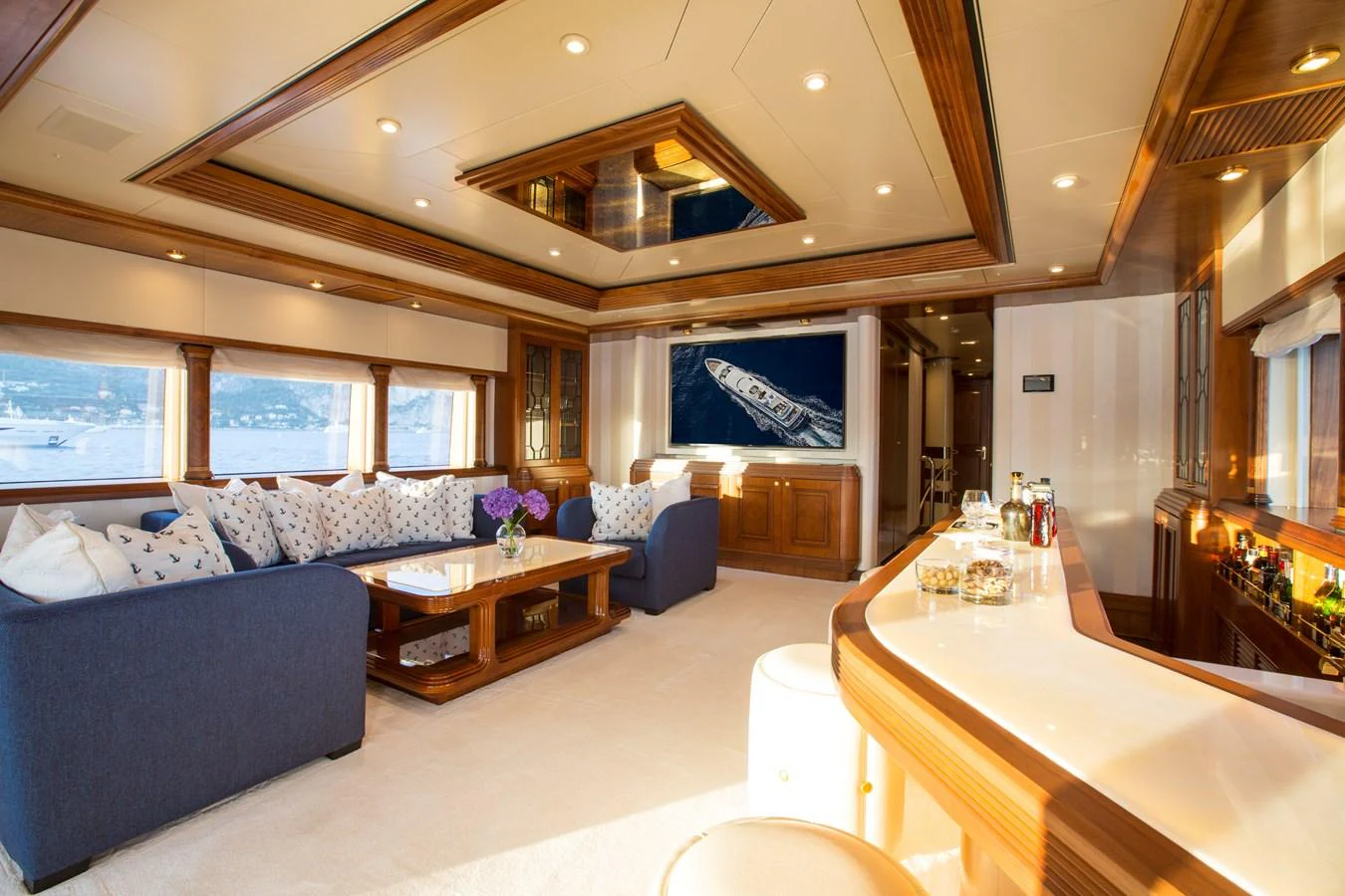 The yacht's salon features elegant seating, a stylish bar, and large windows offering stunning views. aboard ALASKA OF GEORGE TOWN Yacht for Sale