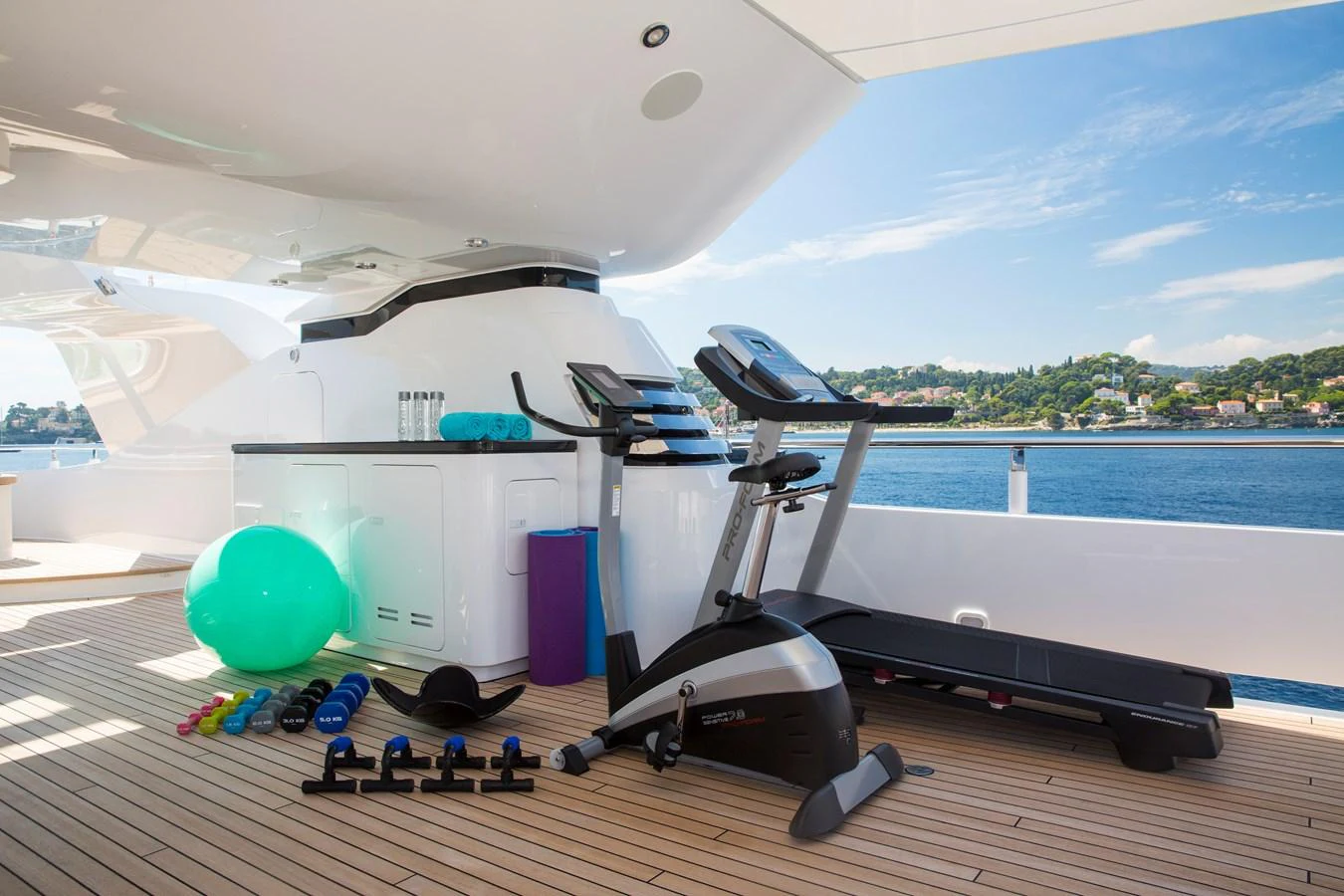 The yacht features a well-equipped outdoor gym area with stunning sea views. aboard ALASKA OF GEORGE TOWN Yacht for Sale