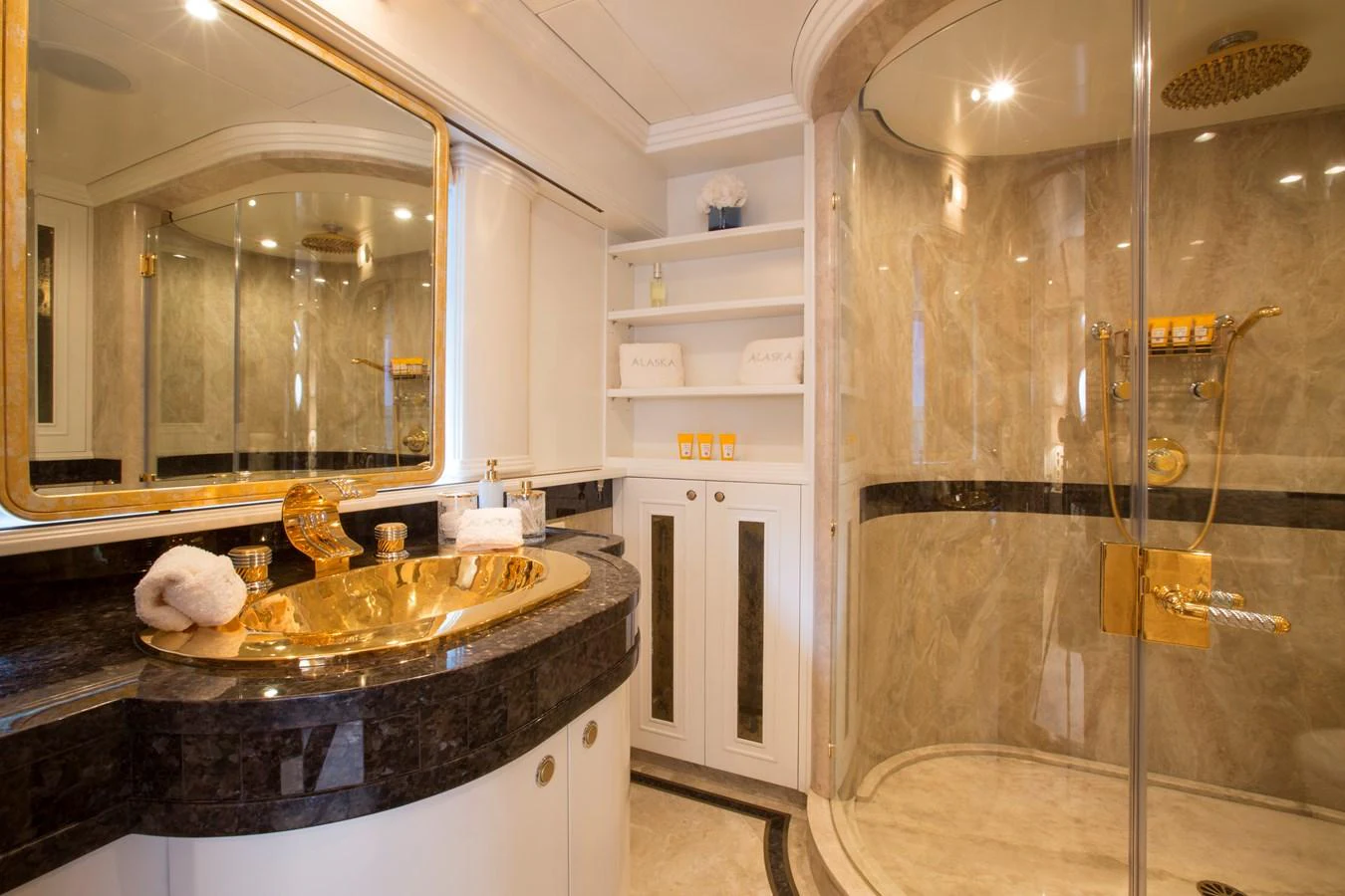 The yacht's bathroom features luxurious gold fixtures and elegant marble accents. aboard ALASKA OF GEORGE TOWN Yacht for Sale
