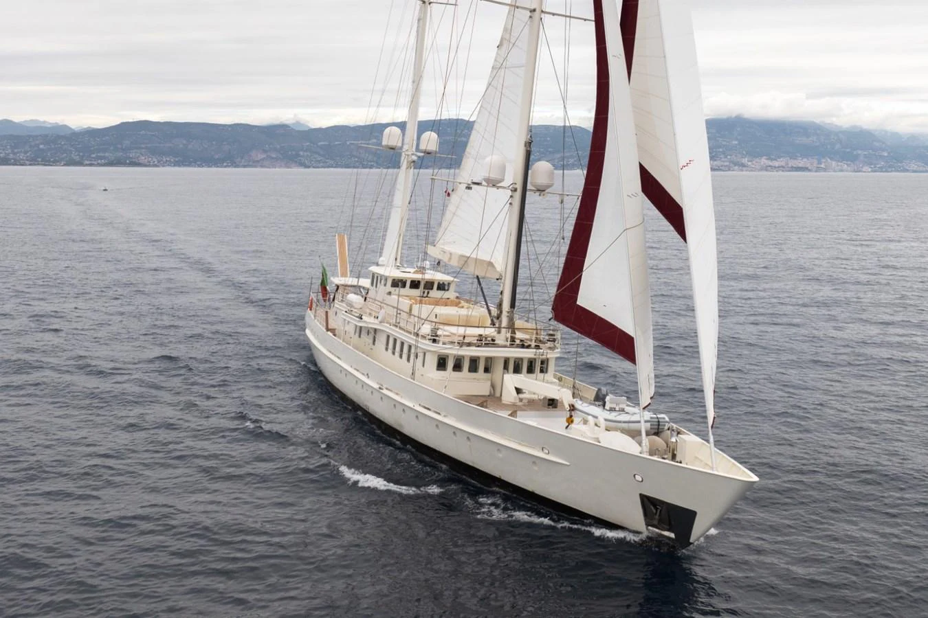 A classic sailing yacht glides gracefully over calm waters with its sails partially unfurled. aboard DIONE STAR Yacht for Sale