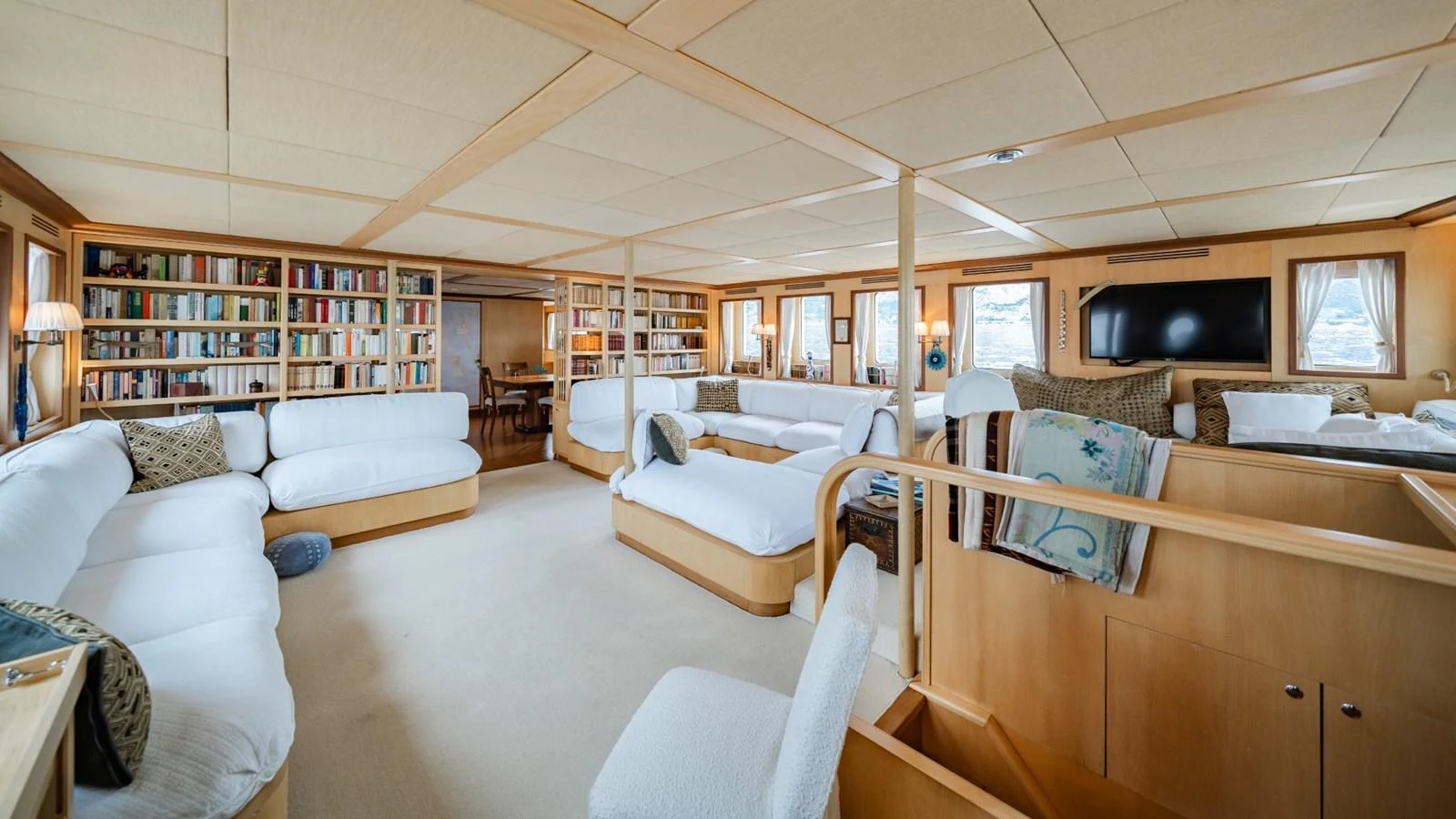 The spacious salon features ample seating, a library, and a large television for entertainment. aboard DIONE STAR Yacht for Sale