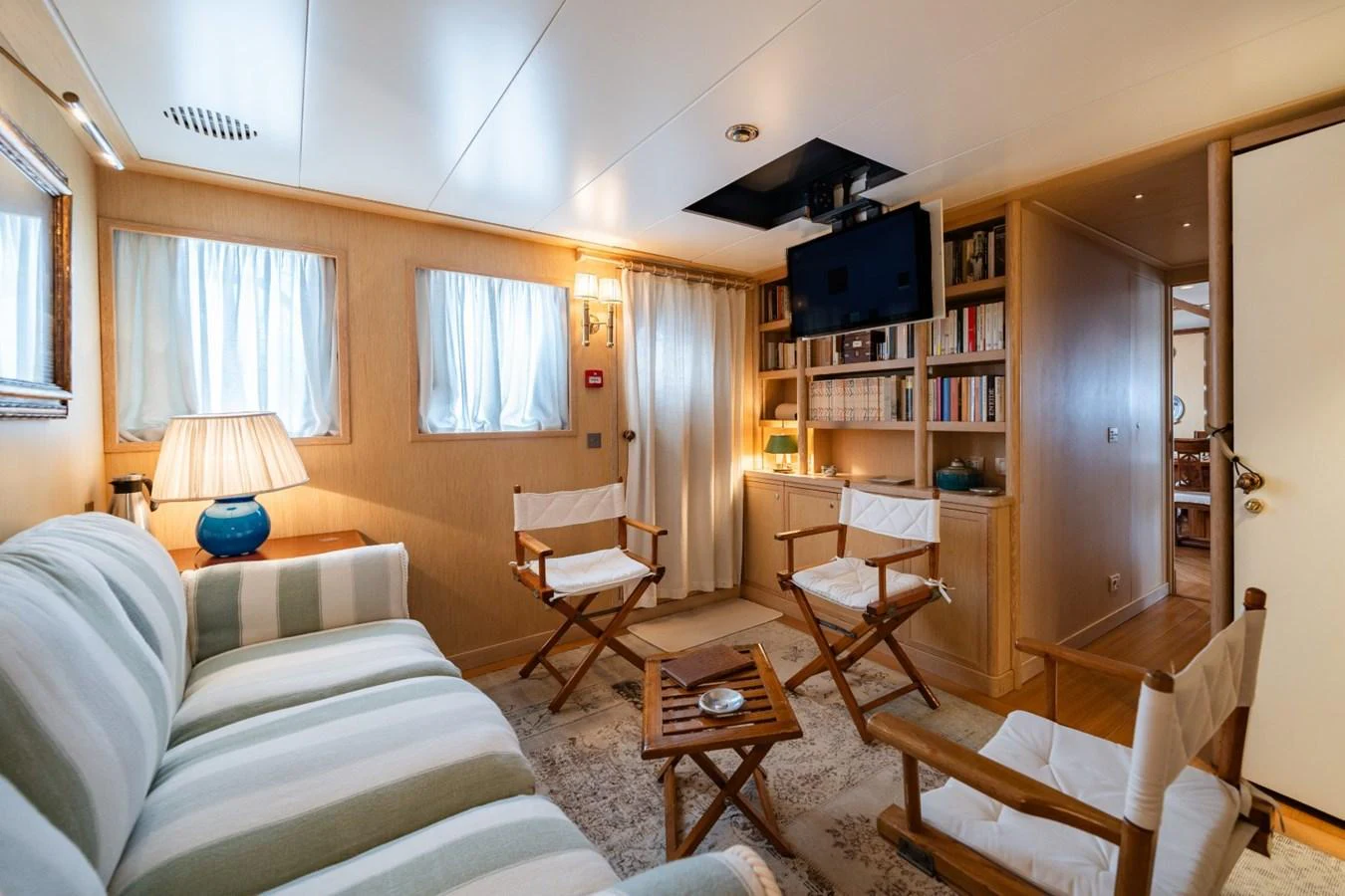 The cozy salon features comfortable seating, a flat-screen TV, and ample natural light. aboard DIONE STAR Yacht for Sale