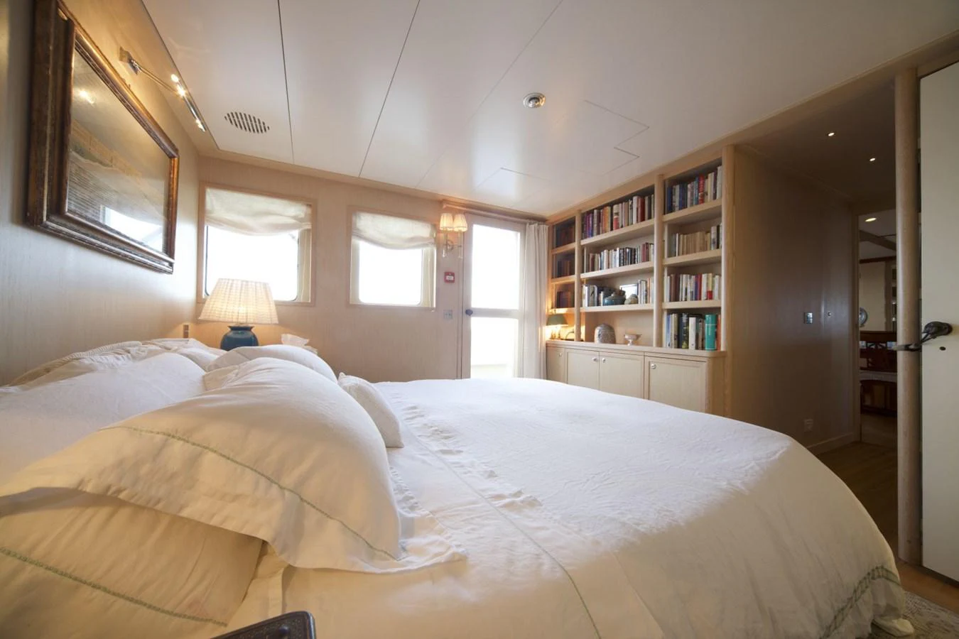 The stateroom features a cozy bed with plush linens and ample natural light from the windows. aboard DIONE STAR Yacht for Sale