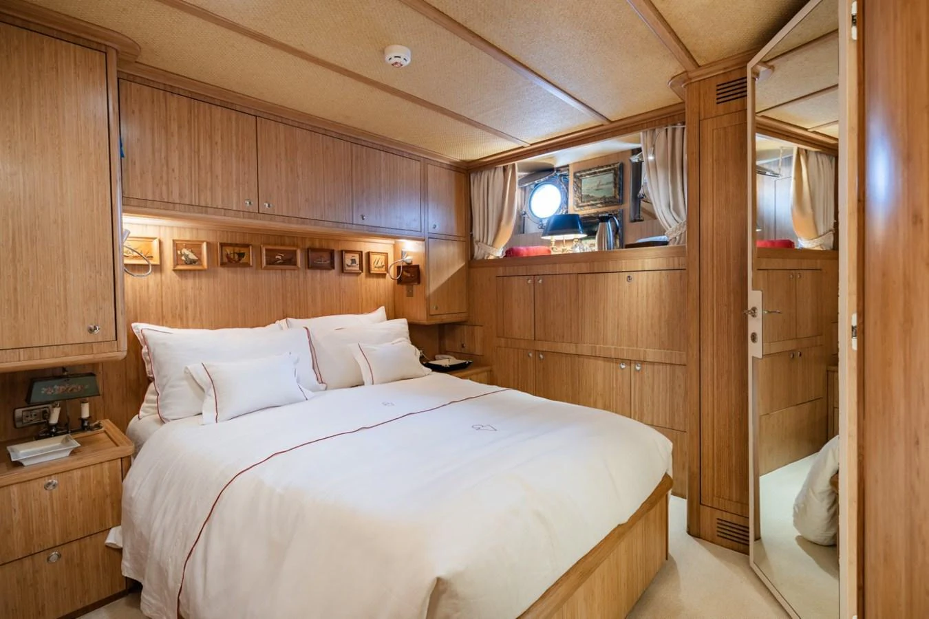 The stateroom features a cozy and elegant design with warm wooden paneling and luxurious bedding. aboard DIONE STAR Yacht for Sale