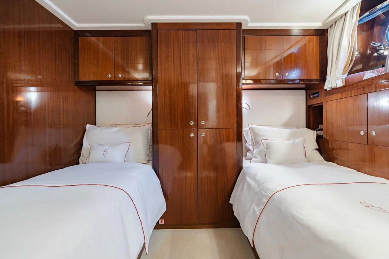 The twin stateroom features two comfortable single beds with elegant wood paneling and soft lighting. aboard DIONE STAR Yacht for Sale
