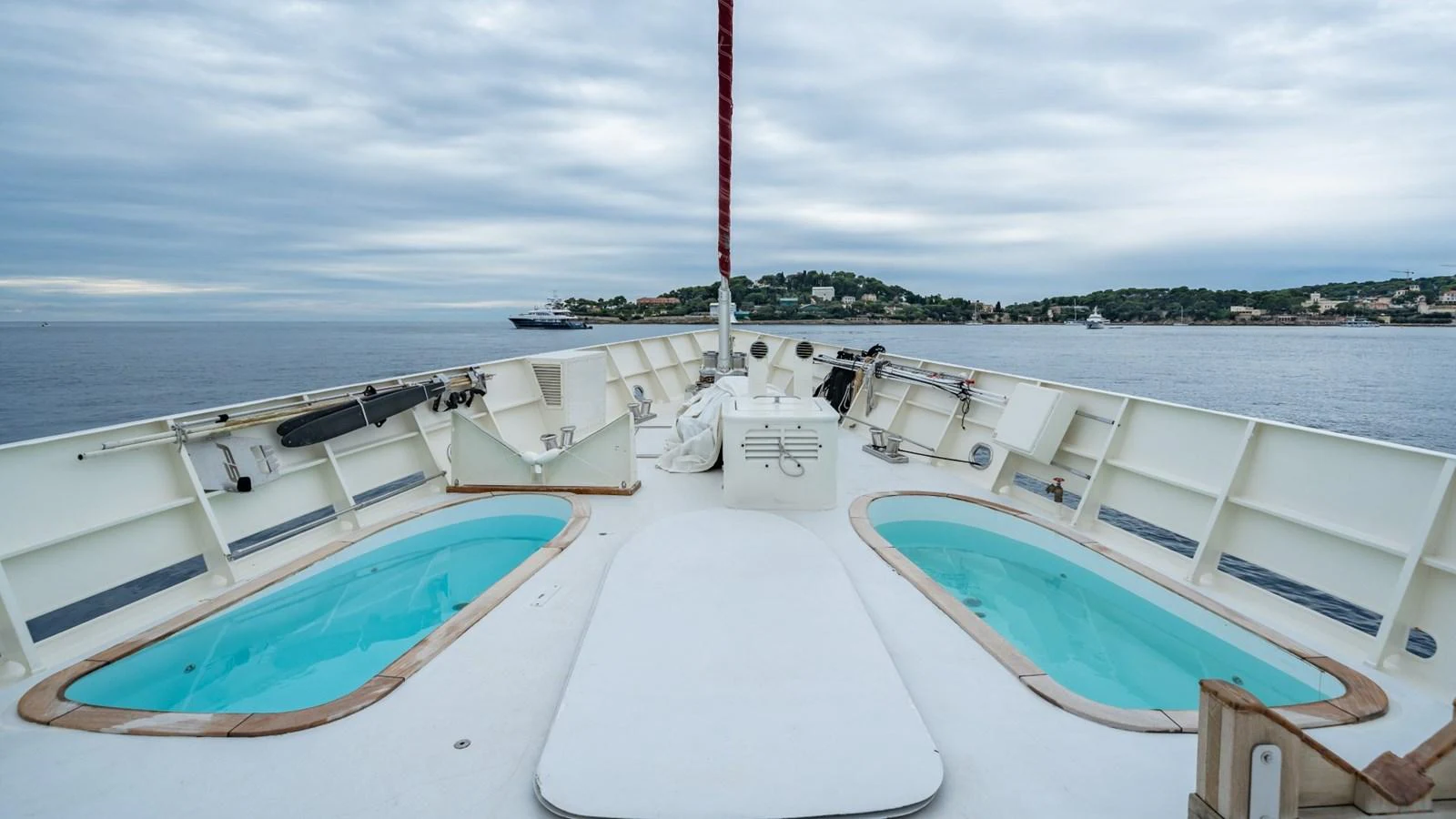 The foredeck features twin pools and a spacious lounging area with a scenic view of the coastline. aboard DIONE STAR Yacht for Sale
