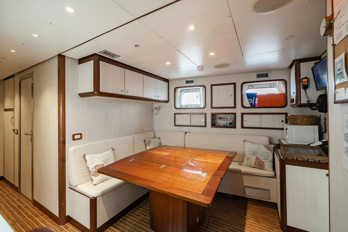 The yacht's dining area features a wooden table surrounded by comfortable seating, creating a cozy and inviting atmosphere. aboard DIONE STAR Yacht for Sale