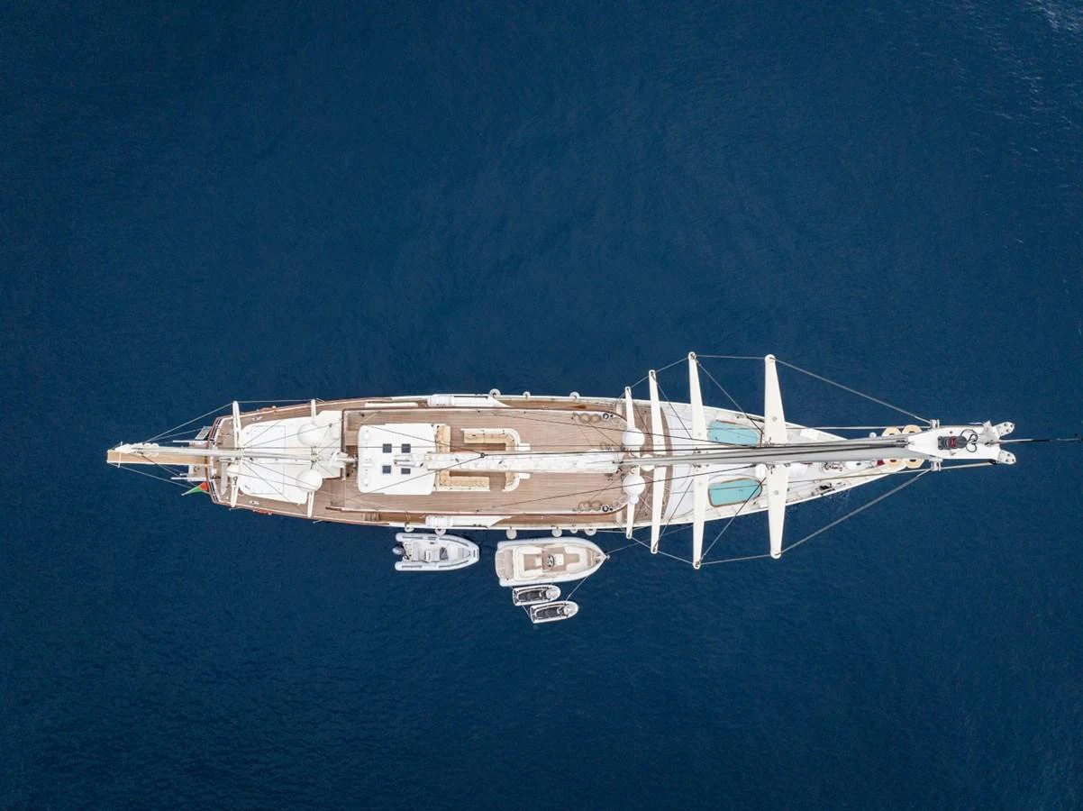 An aerial view of a luxurious yacht with tenders floating beside it on the deep blue sea. aboard DIONE STAR Yacht for Sale