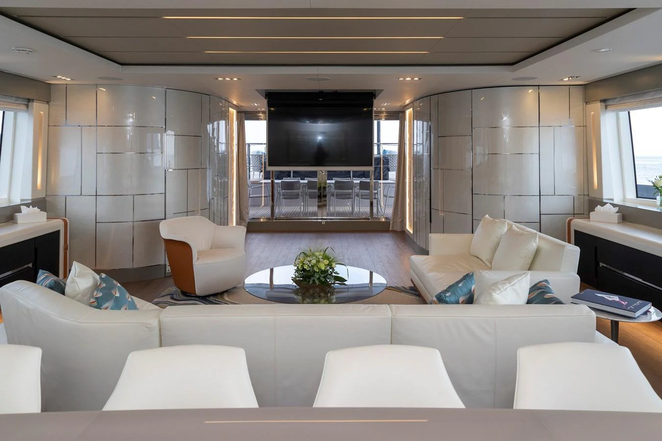 The yacht's interior features a spacious and modern living area with luxurious seating and a large TV. aboard PERSHING 140 Yacht for Sale