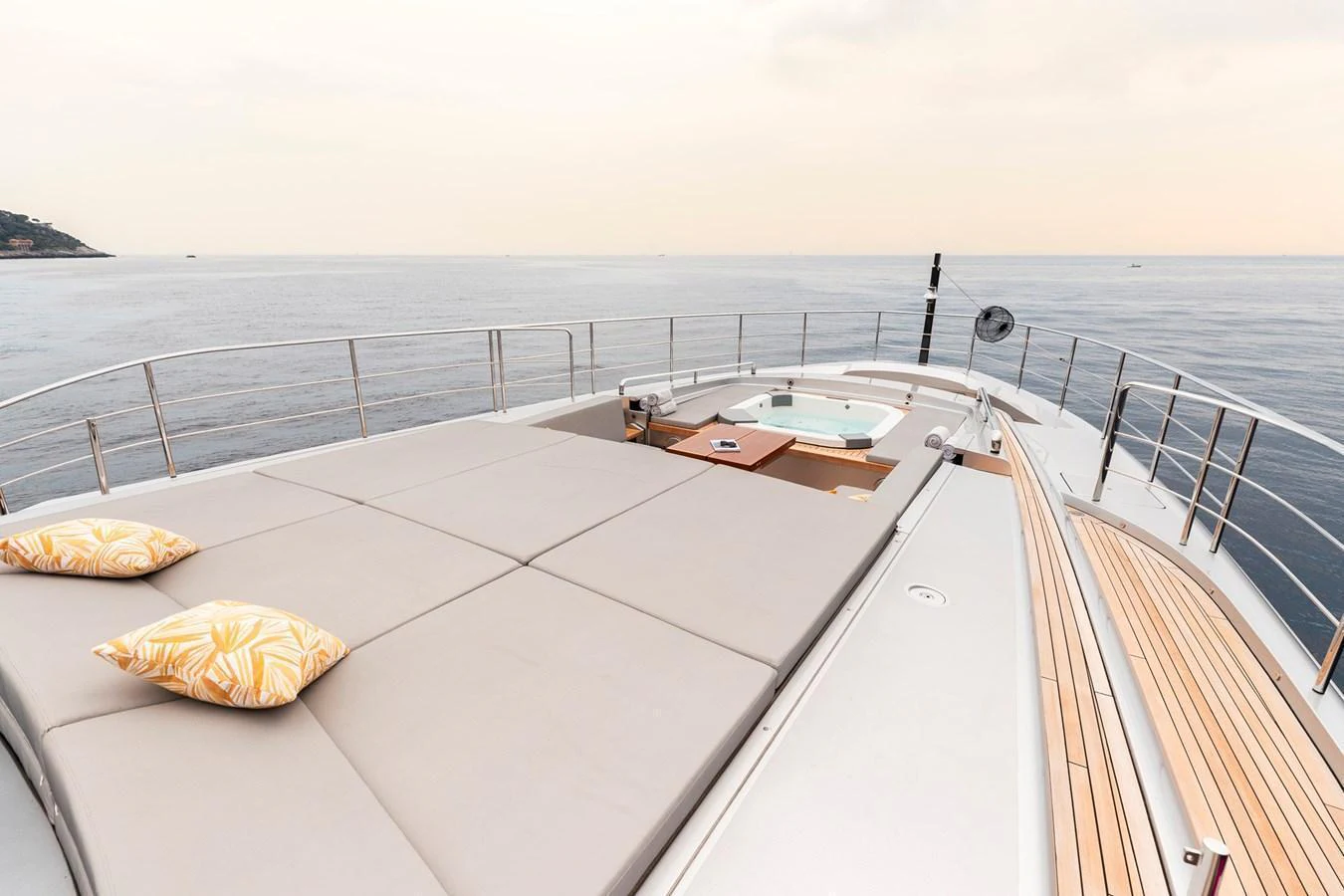 The foredeck features a spacious sunbathing area with plush cushions and a jacuzzi, offering a serene view of the open sea. aboard PERSHING 140 Yacht for Sale