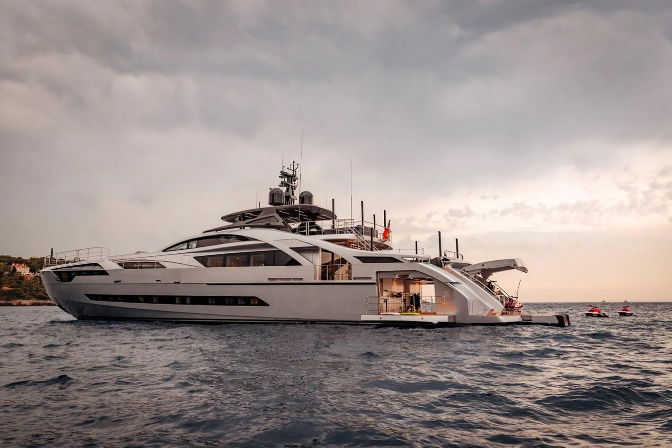 A sleek and modern yacht is anchored on calm waters under a cloudy sky. aboard PERSHING 140 Yacht for Sale