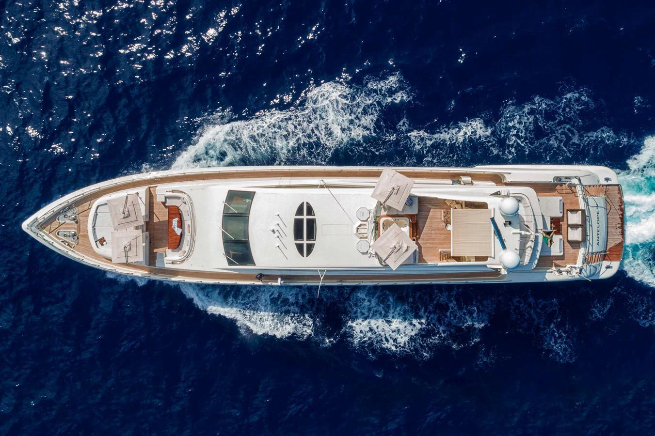 A stunning aerial view of a luxurious yacht cruising through deep blue waters. aboard ANTELOPE IV Yacht for Sale