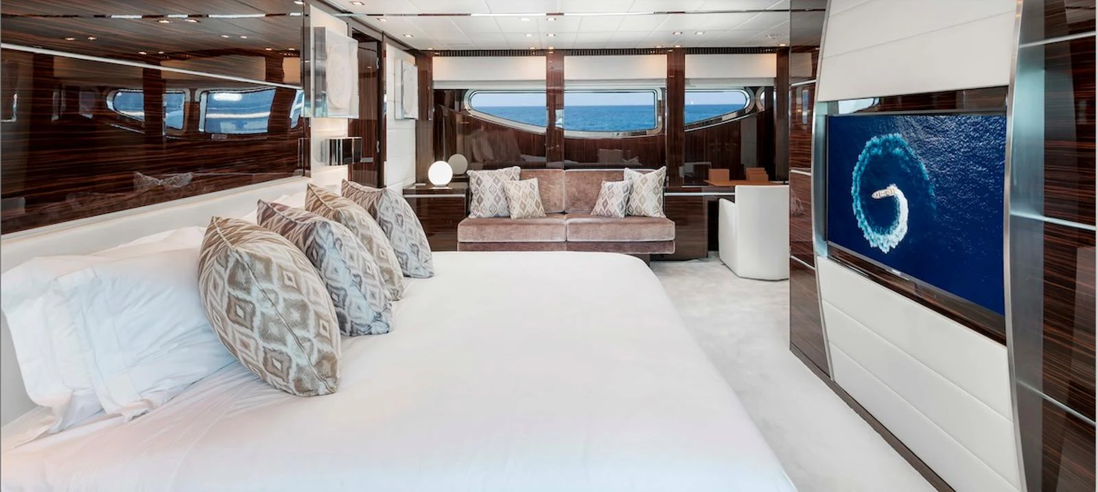 The master stateroom features a luxurious bed, ample seating, and a large flat-screen TV with ocean views through the windows. aboard ANTELOPE IV Yacht for Sale