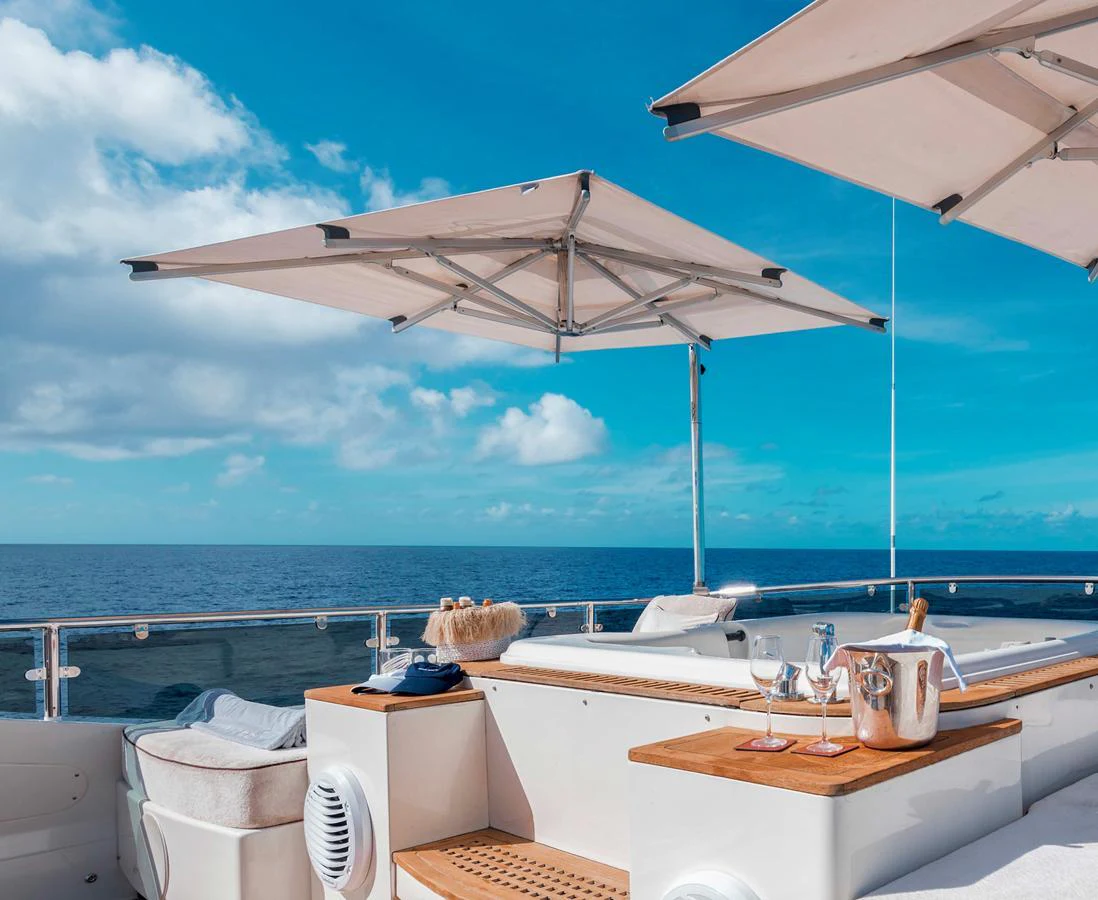 The sundeck offers a luxurious space with sun loungers, parasols, and a stunning ocean view. aboard ANTELOPE IV Yacht for Sale