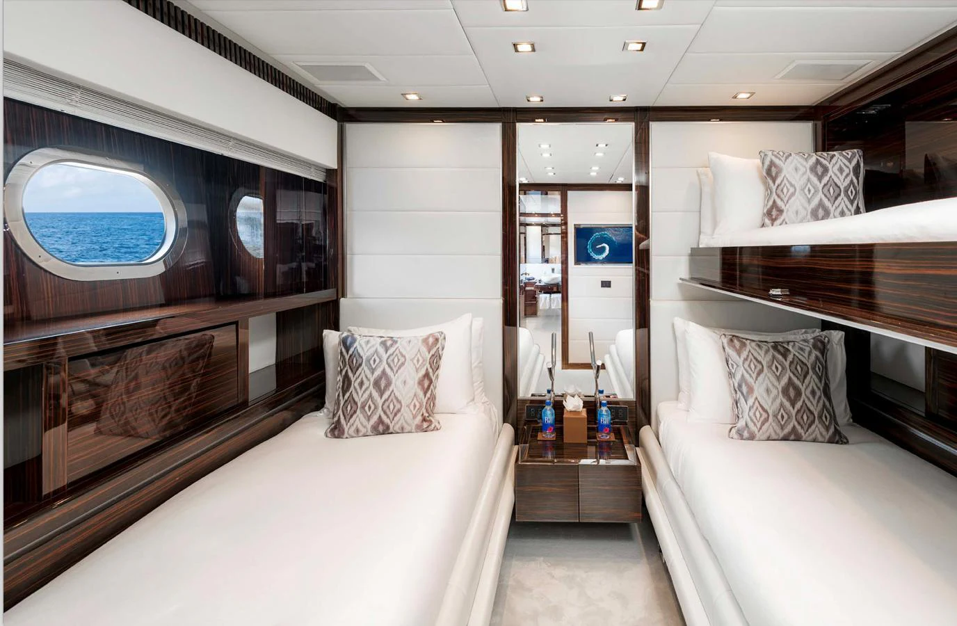The guest stateroom features twin beds with elegant bedding and a view of the sea through a porthole. aboard ANTELOPE IV Yacht for Sale