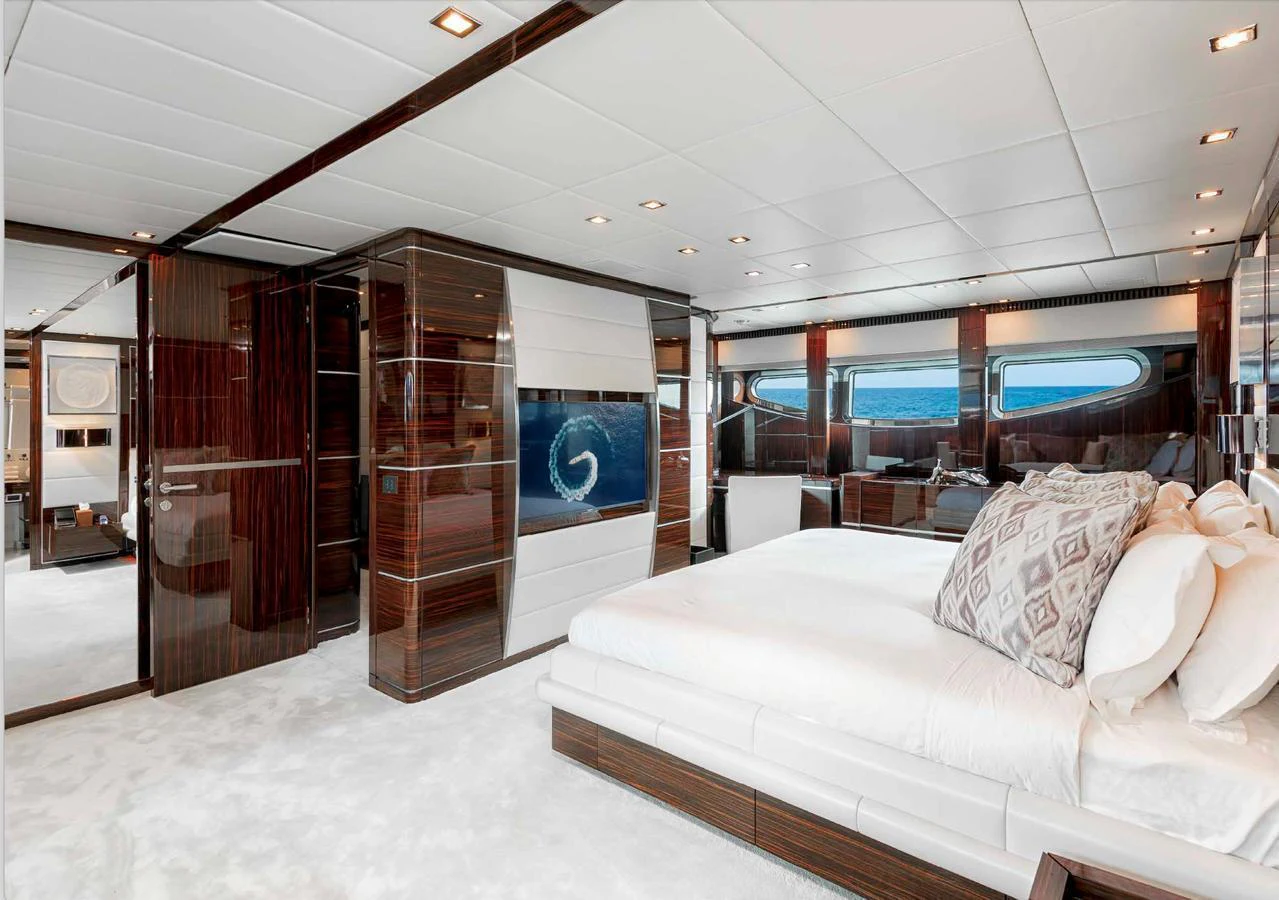 The master stateroom features luxurious bedding and elegant wood finishes, offering a serene retreat with ocean views. aboard ANTELOPE IV Yacht for Sale