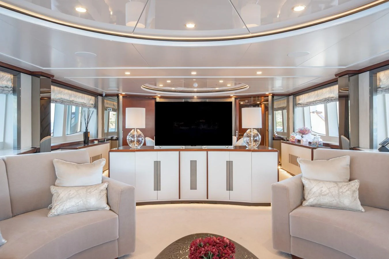 The yacht's interior features a luxurious and spacious lounge area with elegant furnishings and a large flat-screen TV. aboard TITIAN PEARL Yacht for Sale