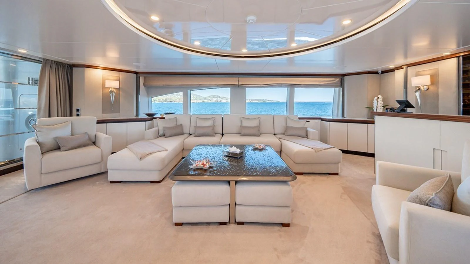 The spacious salon features plush seating and panoramic windows offering stunning sea views. aboard TITIAN PEARL Yacht for Sale