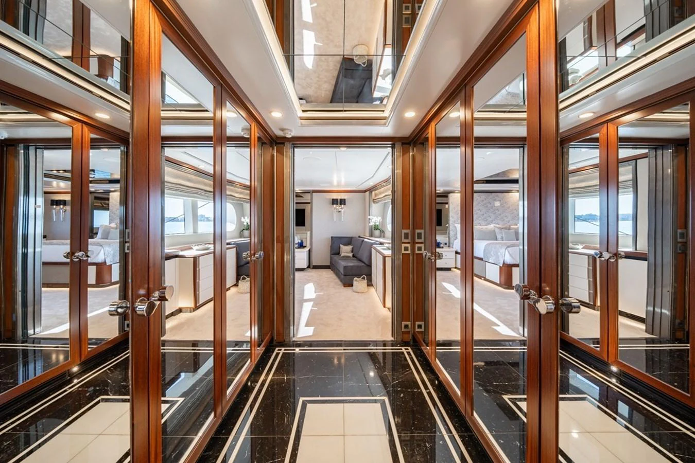 The luxurious interior hallway features elegant wood paneling and mirrored walls, leading to a spacious lounge area. aboard TITIAN PEARL Yacht for Sale