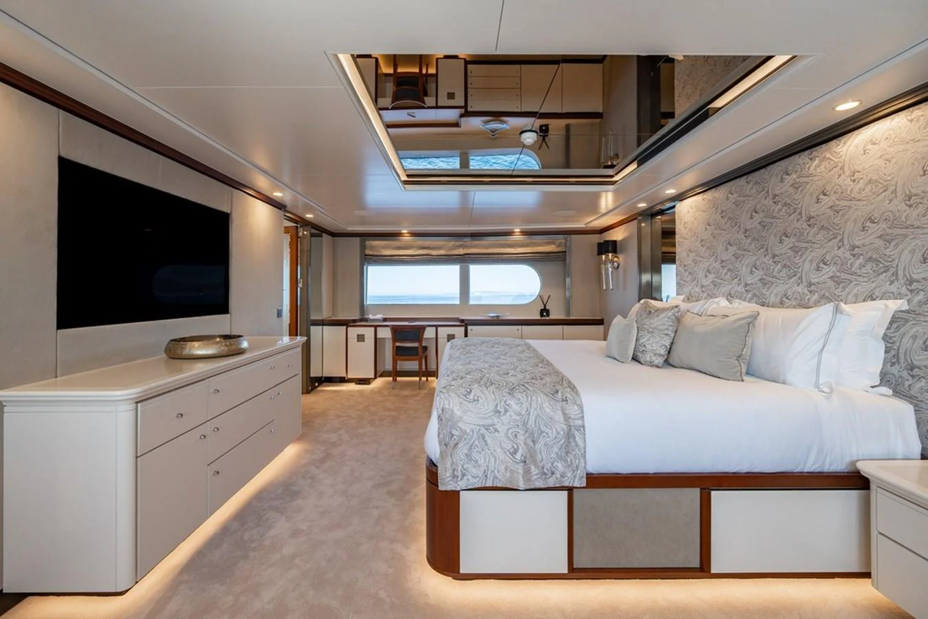 The master stateroom features a luxurious bed, elegant decor, and ample natural light. aboard TITIAN PEARL Yacht for Sale