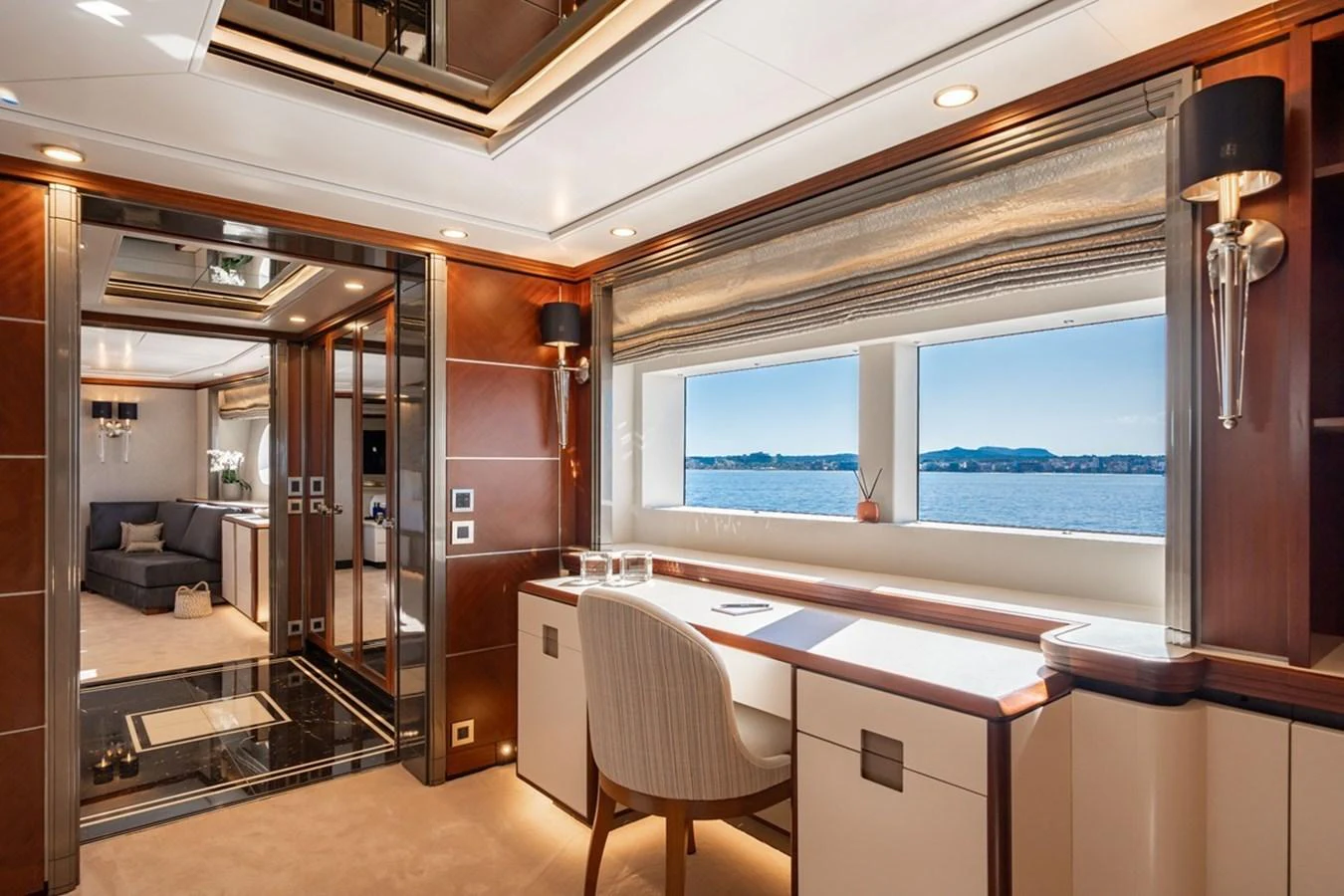 This luxurious yacht office features elegant wood paneling, a large window with a stunning sea view, and modern furnishings. aboard TITIAN PEARL Yacht for Sale