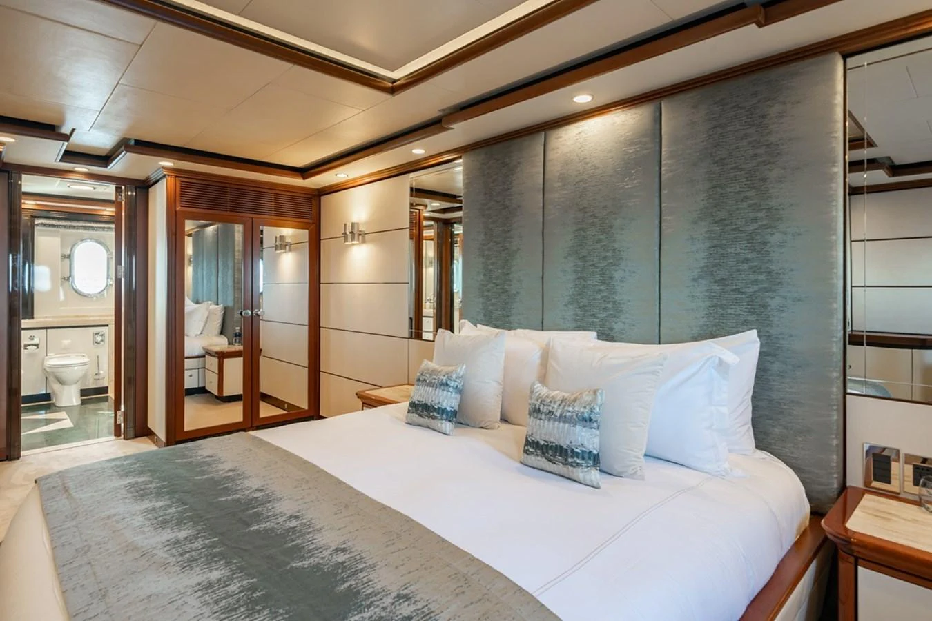 The master stateroom features a luxurious bed with elegant decor and ample natural light. aboard TITIAN PEARL Yacht for Sale